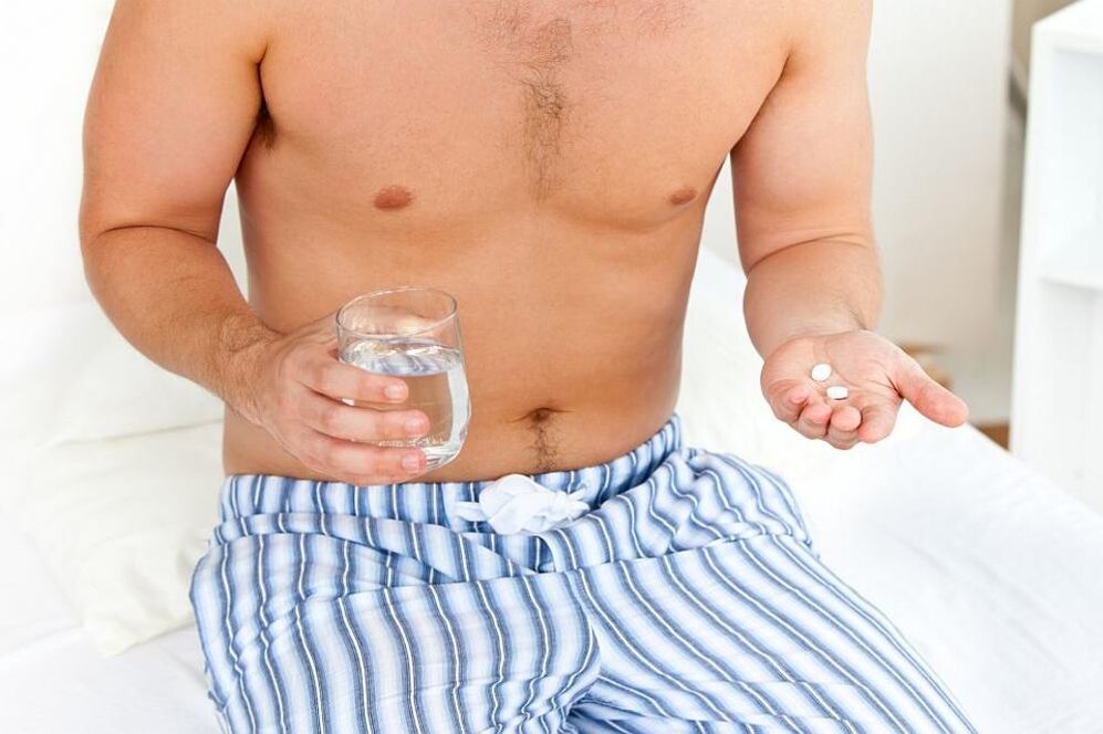 Mann nimmt Tabletten gegen Prostatitis